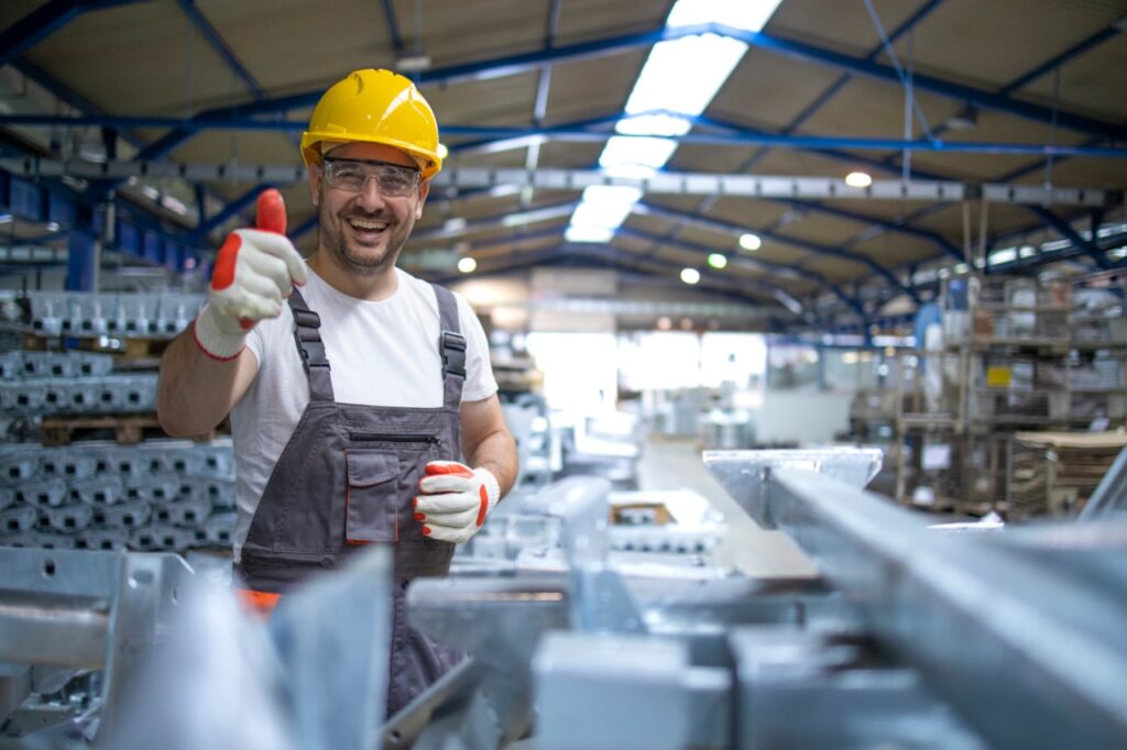 portrait ouvrier usine dans equipement protection holding thumbs up in production hall min